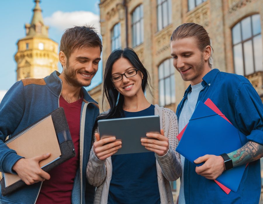 a-group-of-young-multi-ethnic-group-of-student-in-university-smiling-and-looking-at-the-tablet.jpg a-group-of-young-multi-ethnic-group-of-student-in-university-smiling-and-looking-at-the-tablet.jpg